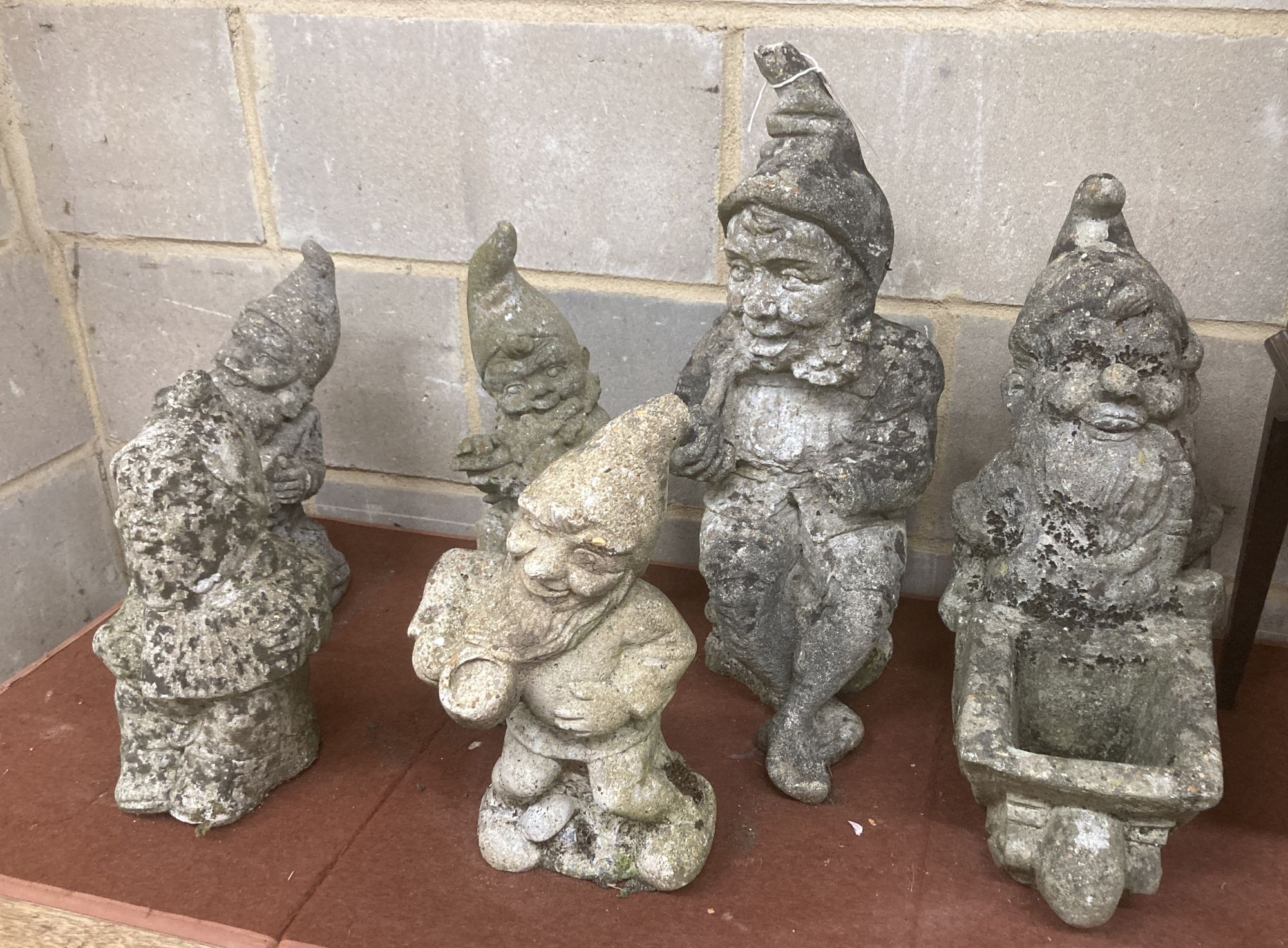 Six reconstituted stone gnome garden ornaments, largest 60cm high